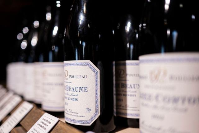 Photo d'illustration : des bouteilles de vin alignées chez un caviste