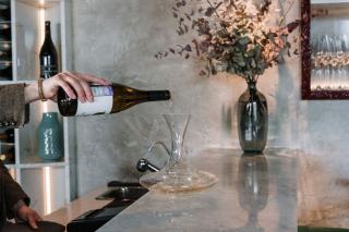 Sommelier présentant une bouteille de vin rouge à une table de restaurant